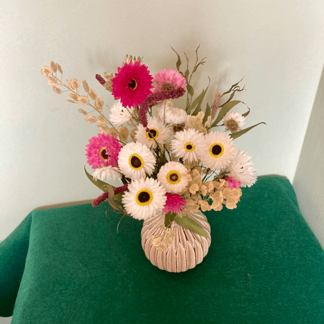 Local dried flower arrangement in vintage beige glazed vase