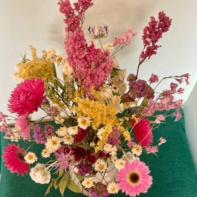 Local dried flower arrangement in vintage style green vase